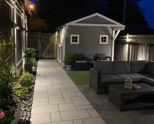 Image depicts a backyard with interlocking walkway.