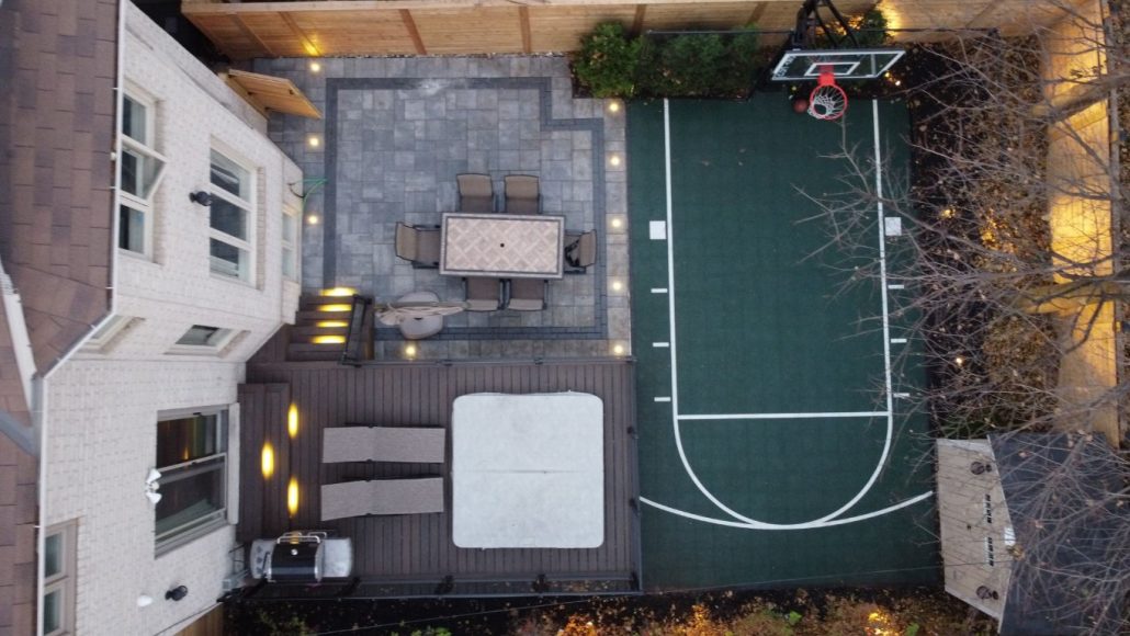 Image depicts a backyard with basketball court