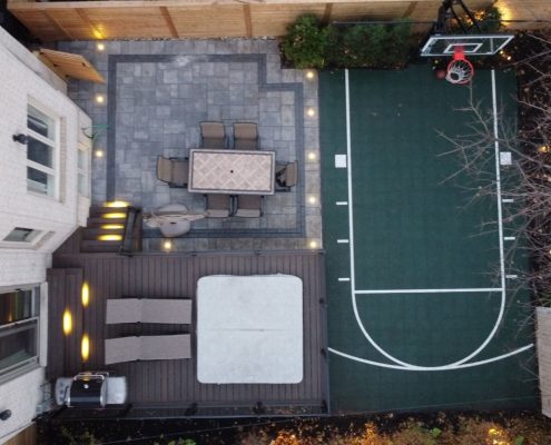 Image depicts a backyard with basketball court