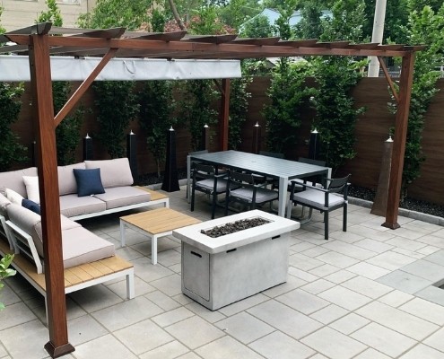 Image depicts an interlocking patio with a modern patio set.
