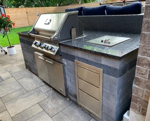 Image depicts an outdoor kitchen installed on a new interlock patio.