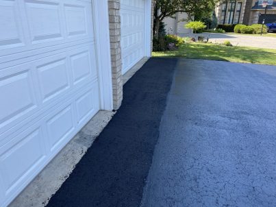 Image depicts asphalt that has been patched and repaired.