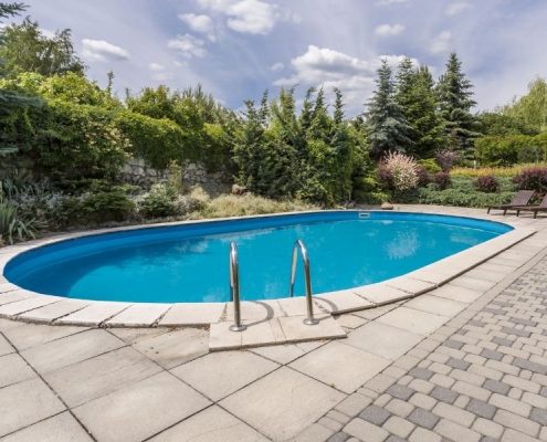 Image depicts a backyard concrete pool.