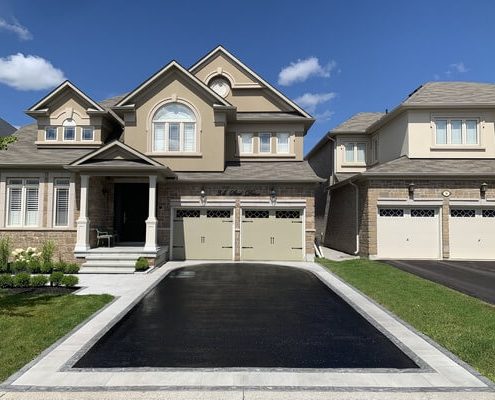 Image depicts a residential asphalt driveway that has been sealed by AHS.