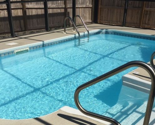 Image depicts a backyard fiberglass pool.