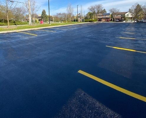 parking-lot-sealing-by-ahs Image depicts an asphalt parking lot that has been sealed by AHS.