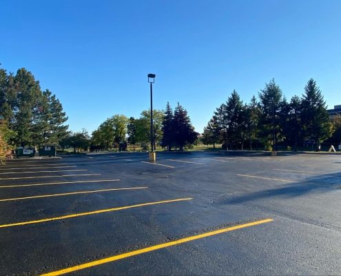 Image depicts a parking lot with sealed asphalt and newly painted parking lines.
