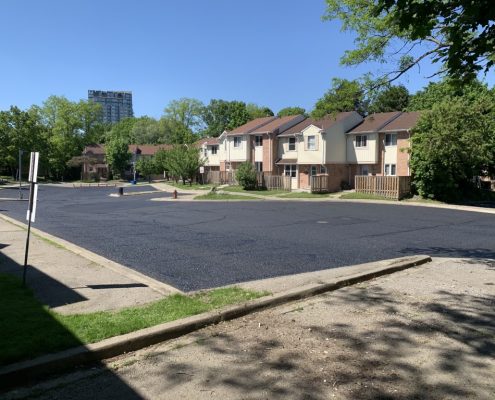 Image depicts a parkign lot with asphalt that has been sealed.