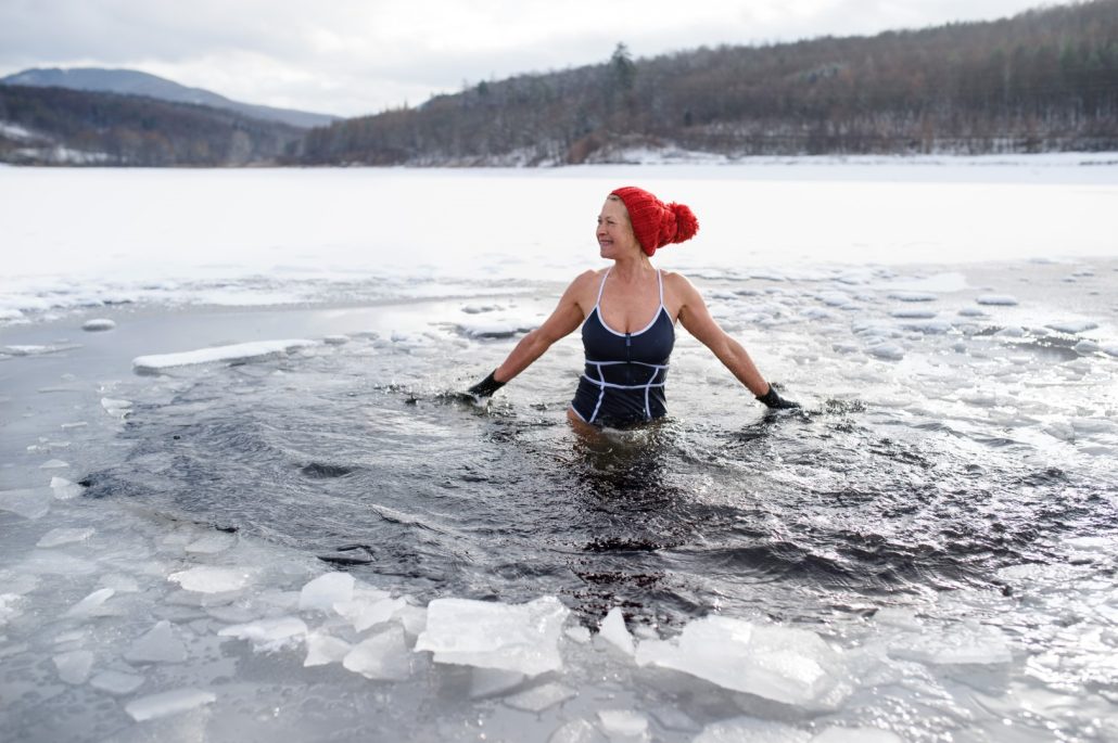 Front view of active senior woman in swimsuit outdoors in winter, cold therapy concept.