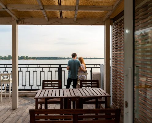 Couple standing on a veranda by lake