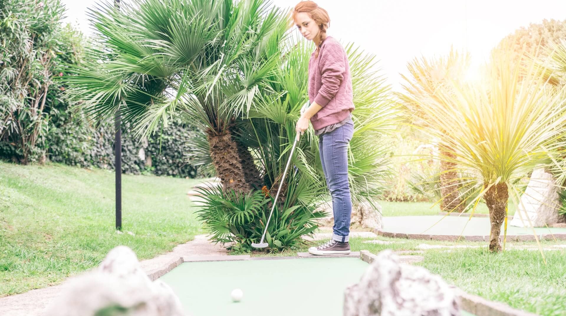 Woman plays mini golf