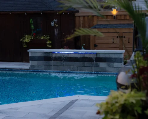 backyard fireplace next to pool and hot tub